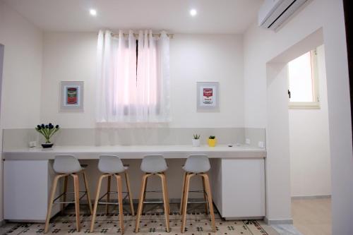 una cucina con bancone bianco e sgabelli di De Nobili's Apartments a Trapani