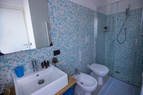 uma casa de banho com um lavatório, um WC e um chuveiro em Giglio Marino em Tortolì