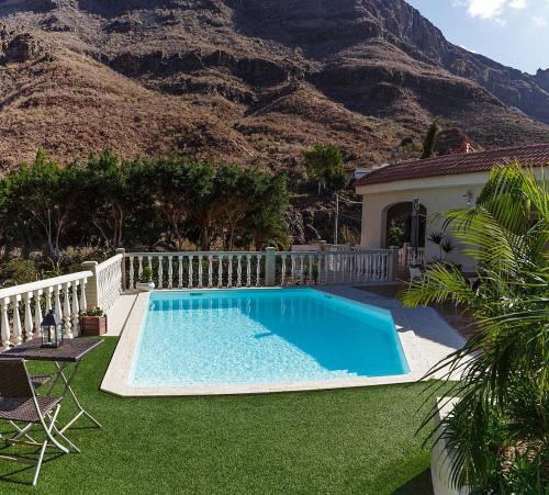 a swimming pool in front of a house with a mountain at Time To Experience in Salobre