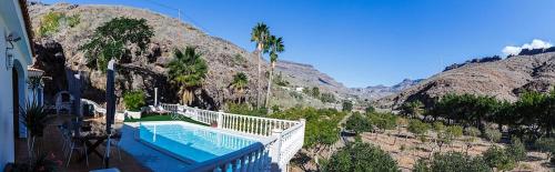 a house with a swimming pool next to a mountain at Time To Experience in Salobre