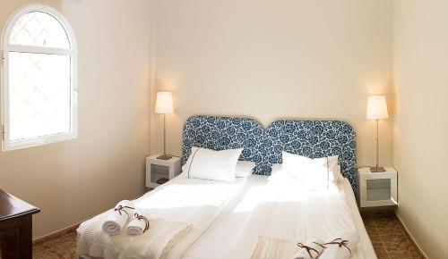 a bedroom with a large bed with a blue and white headboard at Time To Experience in Salobre