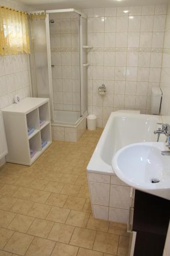 a bathroom with a tub and a sink and a shower at Ferienwohnung Troge in Kurort Gohrisch