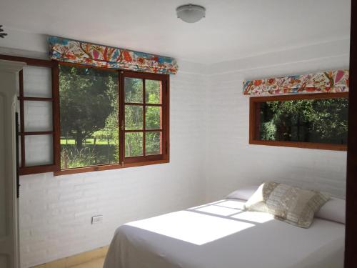 1 dormitorio con 1 cama y 2 ventanas en Raco De La Calma en Nono
