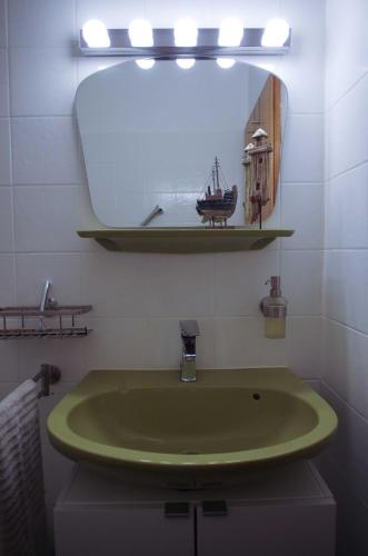 La salle de bains est pourvue d'un lavabo vert et d'un miroir. dans l'établissement Ferienwohnung Waldgimpel Schmitten, à Schmitten