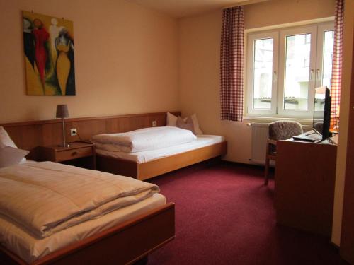 a hotel room with two beds and a television at Gasthaus Neupert in Lemberg