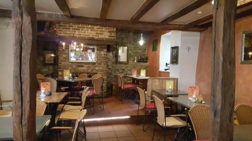 ein Restaurant mit Tischen und Stühlen und einer Ziegelwand in der Unterkunft Gästehaus By George in Stolberg