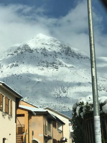 a mountain covered in snow in front of houses at B&B mò•sì in Massa dʼAlbe