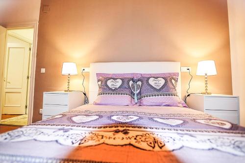 a bedroom with a large bed with two lamps at Apartamento La Paz in Logroño