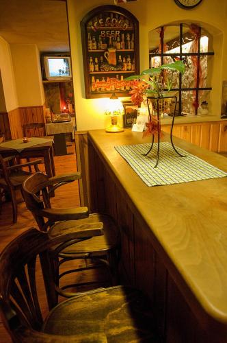 a bar with two chairs and a counter in a restaurant at Penzión Pod bránou in Poprad