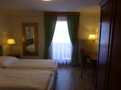 a hotel room with two beds and a desk and a window at Haus Zegg in Nauders