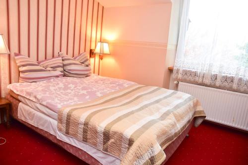 a bedroom with a bed with pillows and a window at Cichy Kącik w Karpaczu in Karpacz