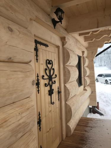 a wooden door in a log cabin with snow at Chochołowskie Spanie in Chochołów