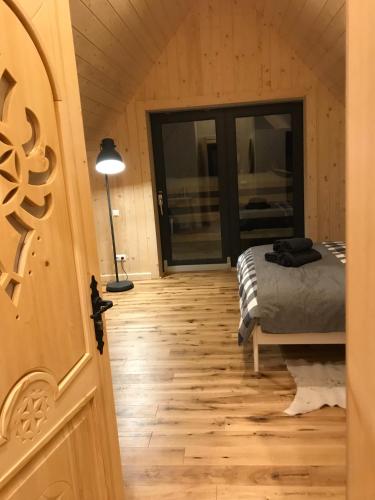 a bedroom with a bed and a lamp on a wooden floor at Chochołowskie Spanie in Chochołów