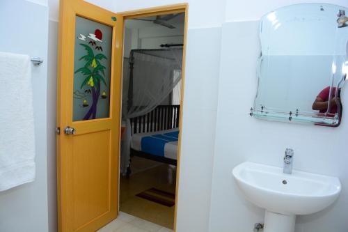 a bathroom with a sink and a mirror at Kabalana Design House Villa in Ahangama