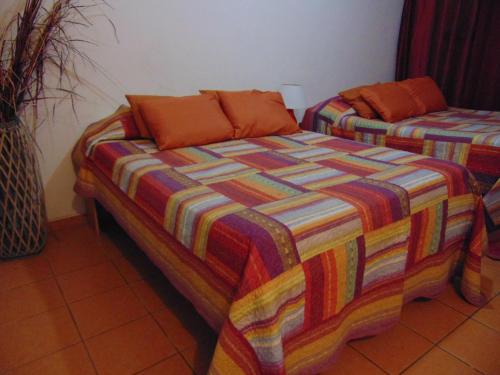 a bed with a colorful blanket on it in a room at Casa Lima B&B in San José