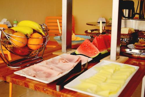 a table with cheese and fruit on a table at Hotel A Mi Gente in Castillos