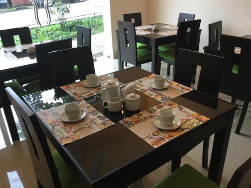 a dining room table with cups and saucers on it at Tariri Hotel in Pucallpa