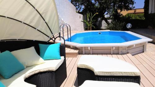 a hot tub sitting on a deck with two chairs at HB Le suites del Giardino in Taranto