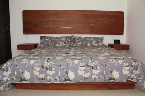 1 dormitorio con cama con colcha gris y blanca en Charming Apartment within Bahia Principe 5*, en Akumal