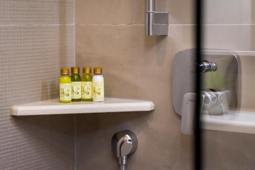tres botellas de aceites sentadas en un estante en un baño en Room St. Jacob Dubrovnik, en Dubrovnik