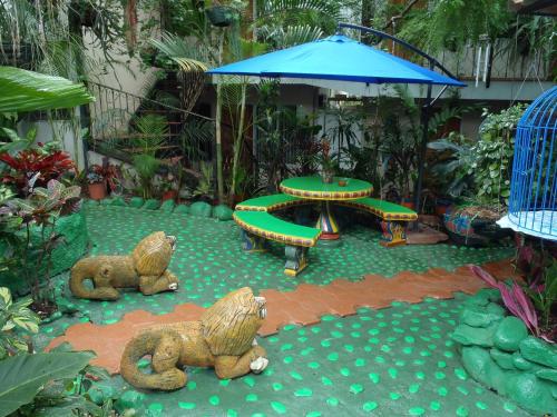 a garden with a table and chairs and an umbrella at Casa Lima B&B in San José