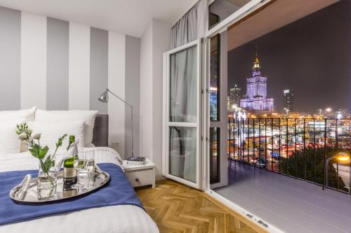 a bedroom with a large window with a city view at GLAM APARTMENTS city center in Warsaw
