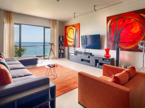 a living room with a couch and a television at Malaiwana Villas in Nai Thon Beach