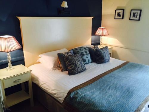 um quarto com uma cama com almofadas em Mason's Arms em Bowland Bridge