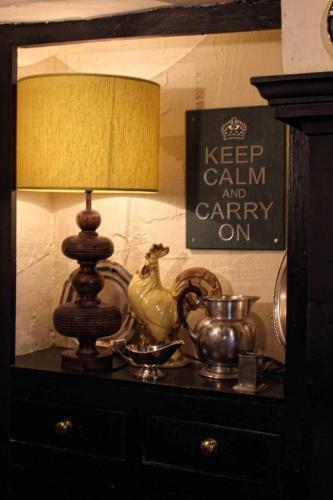 a lamp sitting on a dresser with a table with a mirror at Mason's Arms in Bowland Bridge