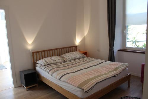 łóżko w sypialni z oknem w obiekcie Atelier 55 Casa arte e natura w Como