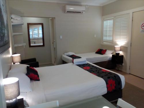 Habitación de hotel con 2 camas y sofá en Brisbane Street Studios en Brisbane