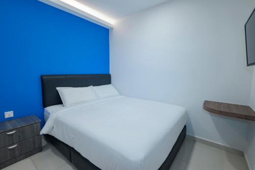 a bedroom with a white bed and a blue wall at G3 HOUSE in Johor Bahru