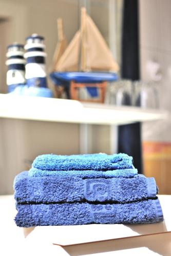 Ein Stapel blauer Handtücher lag auf einem Tisch. in der Unterkunft Ti Er Mad in Kernascléden