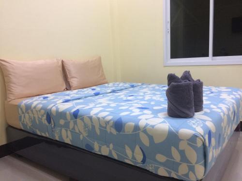 a bed with two stuffed animals sitting on it at Bannrommai Sattahip in Sattahip