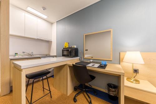a kitchen with a desk with a computer and two chairs at Days Hotel & Suites by Wyndham Incheon Airport in Incheon