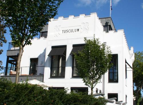 a white building with a sign on it at Villa Tusculum in Binz in Binz