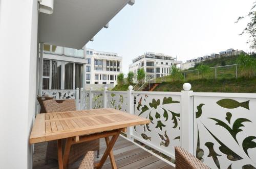 einen Balkon mit einem Holztisch und Stühlen in der Unterkunft Villa "Johanna" Sellin - WG13 mit Kamin und zwei Balkonen in Ostseebad Sellin