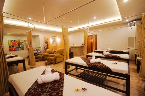 a room with four beds and a living room at Sevn Legian in Legian