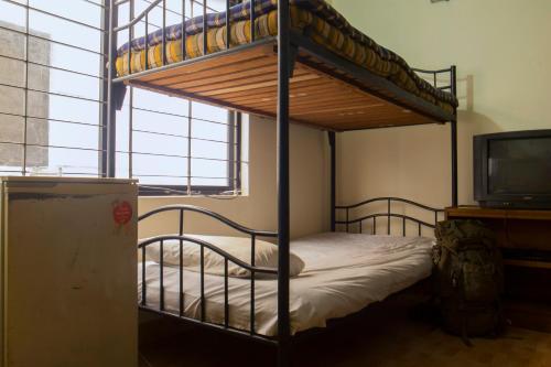 a bedroom with a bunk bed and a television at Japanese lodge hydrangea in Dhaka