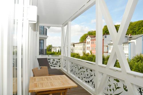 オストゼーバート・ゼリンにあるVilla "Johanna" Sellin - WG12 mit Kamin und zwei Balkonenの白いバルコニー(木製テーブル、窓付)