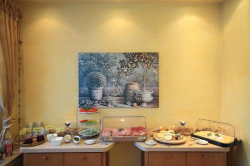 a table with food on it with a painting on the wall at Hotel Zum Goldenen Stern in Prüm
