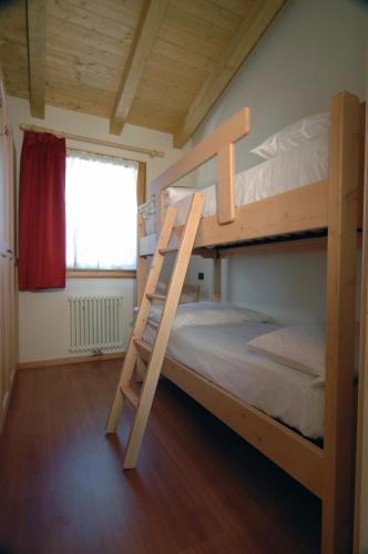 a bedroom with two bunk beds and a ladder at Camping Dolomiti in Dimaro