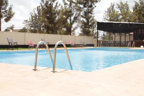 a swimming pool with two metal bars around it at Nyagatare Diplomat Hotel in Nyagatare