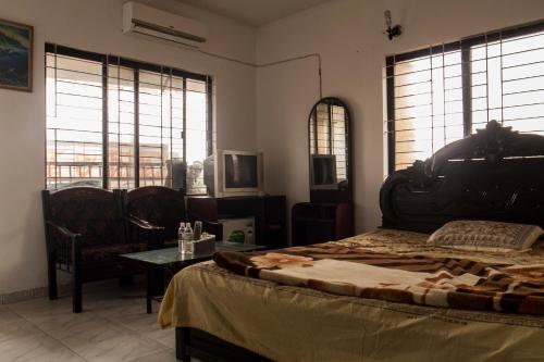 ダッカにある日本人宿あじさいのベッドとテーブルと窓のある寝室