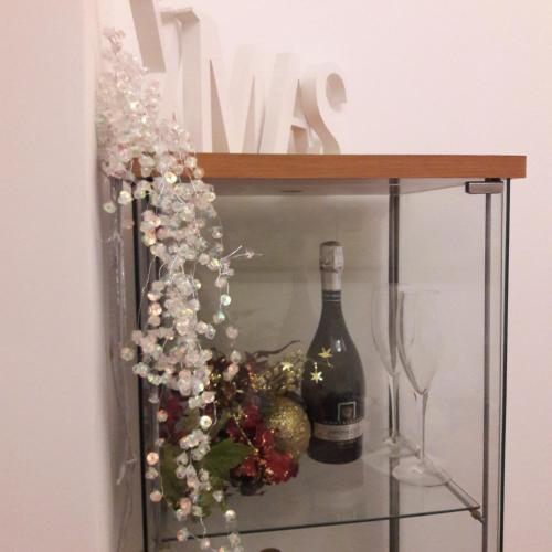a bottle of wine sitting on a shelf with flowers at Hotel Mimosa Pantheon in Rome