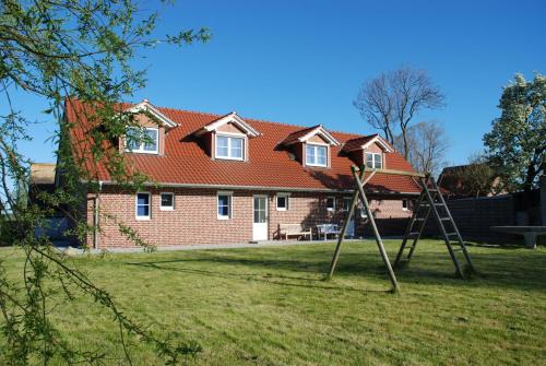 una casa con dos cargadores delante de un patio en Ferienhaus Lobbe - Wohnung 04 mit Terrasse strandnah en Lobbe