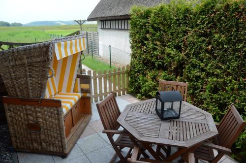 a patio with chairs and a table with a phone on it at Ferienhaus Lobbe - WG 02 über zwei Etagen, strandnah in Lobbe