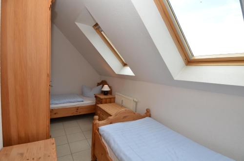 a small room with two beds and a window at Ferienhaus Lobbe - WG 02 über zwei Etagen, strandnah in Lobbe
