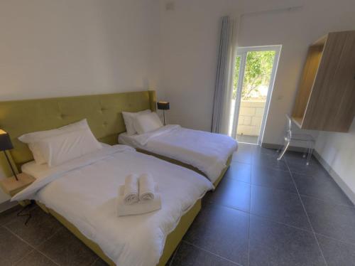 a bedroom with two beds with white towels on them at Le Margherite in Kalkara