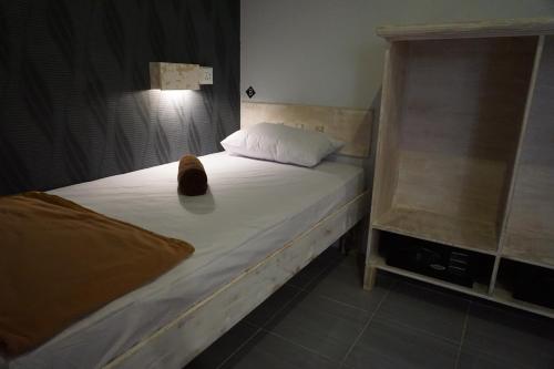 a cat sitting on a bed in a bedroom at M BOX Gili Trawangan in Gili Trawangan